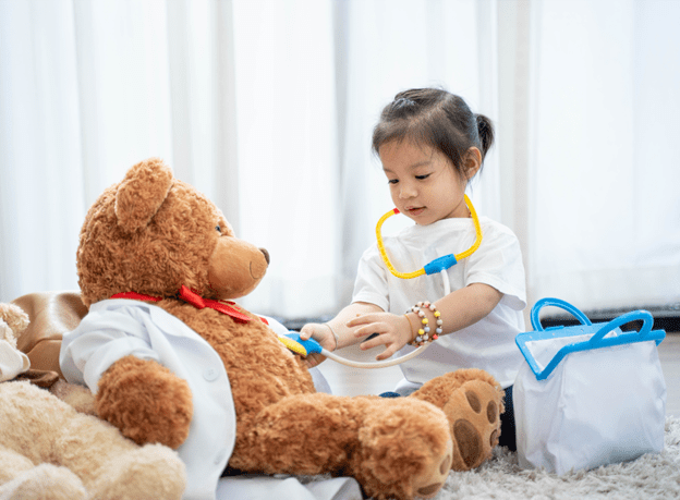 Child-centred play therapy - playing nurse with teddy bear
